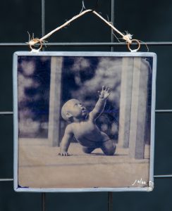 Ambrotype on blue stained glass of a child sculpture