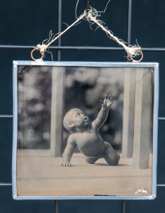 Ambrotype of a child sculpture on black stained glass